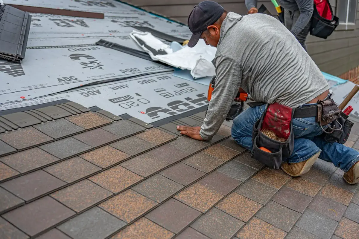 Roofer installing new asphalt shingles
